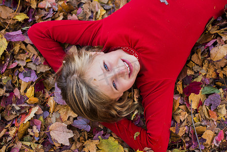 年轻女孩的肖像躺在秋叶里