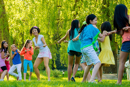春风十里美丽如你摄影照片_一群女子和一群女孩在公园里拔河