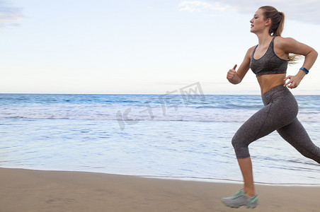年轻的女跑步者沿着多米尼加加勒比海的海滩跑步