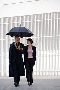 商务人士在雨伞下行走