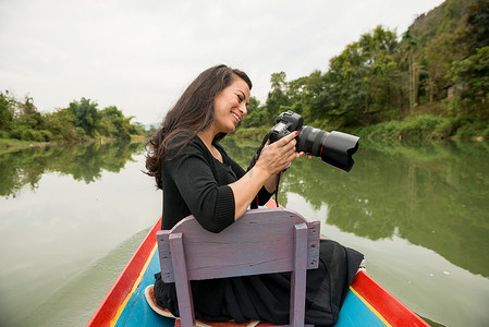 老挝万荣南宋河上带相机的女人
