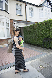 戴着婴儿吊带的成熟母子在街上闲逛