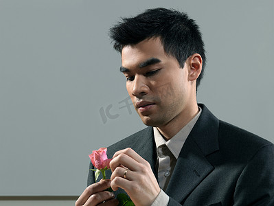 爱情邮局摄影照片_手持粉色玫瑰的男子