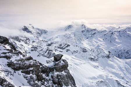 瑞士风光摄影照片_瑞士铁力斯山白雪覆盖的风景和低矮的云彩