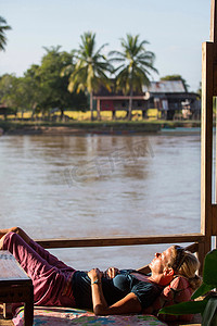 老挝女游客在湄公河游艇上日光浴