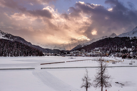 瑞士圣莫里茨日落时山下的村庄雪覆盖的景观
