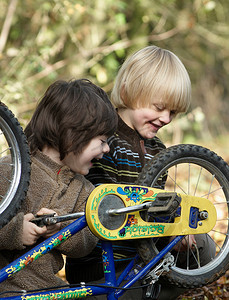 两个男孩在乡间小路上检查自行车