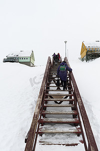 在格陵兰岛伊卢利萨特人们沿着木制楼梯走上的后景