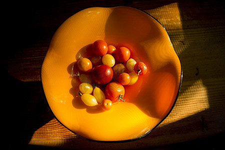 黄狮鱼摄影照片_俯瞰木桌上橙色碗里的西红柿