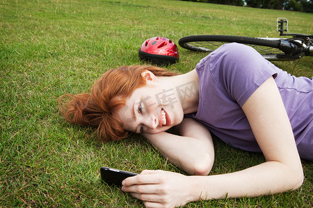 红状摄影照片_躺在草地上的女人发短信