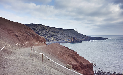 积雪小路摄影照片_西班牙加那利群岛兰萨罗特岛被侵蚀的海岸小路