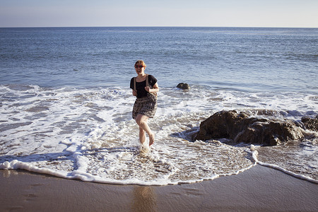 美国加利福尼亚州马里布中年妇女在海上划水的肖像