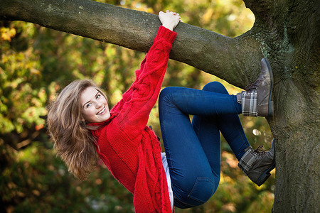 背景攀登摄影照片_十几岁的女孩在公园爬树