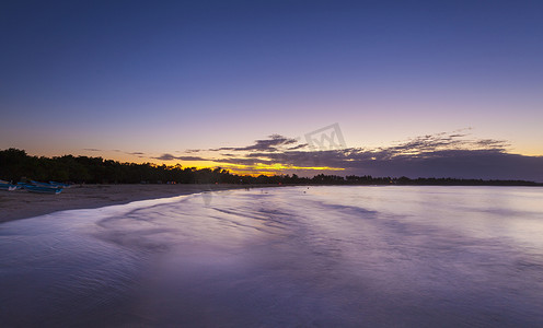 落日流水摄影照片_多米尼加加勒比海海滩上落日的剪影