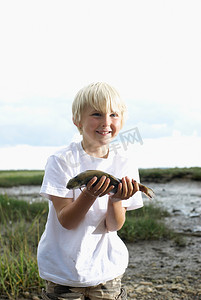安康鱼摄影照片_举着鱼的男孩
