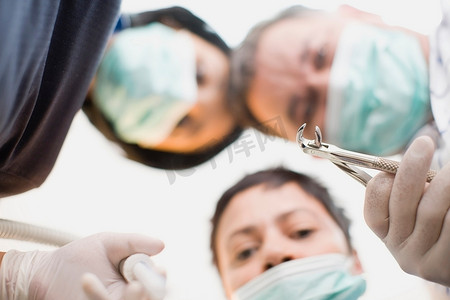 牙医用工具盯着病人看