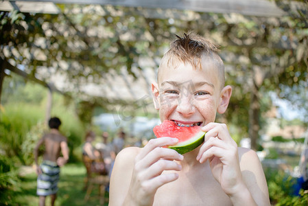男孩在西红柿吃货节上吃西瓜