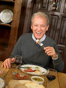 葡萄地摄影照片_老年成人面带微笑地吃午餐
