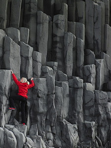 女性攀登玄武岩柱子