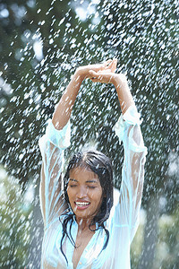 雨中举起双臂的年轻女子肖像