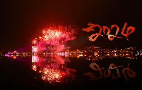 古镇摄影照片_新年夜晚2024龙年烟花古镇摄影图配图