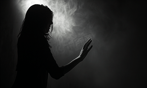 女性焦虑摄影照片_在黑暗中的女性伸手挡在前面