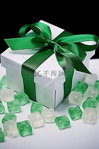 软糖小熊背景图片_一个带有绿色丝带和白色小熊软糖的礼品盒