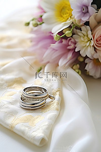 国潮婚纱照背景图片_结婚戒指和手帕坐在桌子上的婚纱上