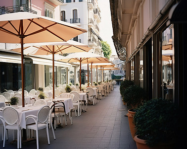 餐厅外的人行道上有白色的遮阳伞和椅子