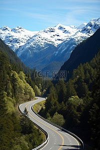 一条高速公路蜿蜒穿过山林，背景是雪山