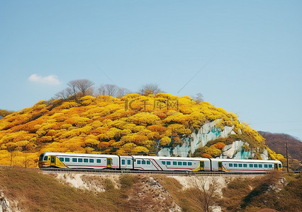春天来背景图片_一列彩色火车驶离一座黄叶小山时缓缓驶来