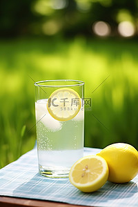 柠檬水背景图片_室外房间草地上的桌子上放着柠檬水，上面有柠檬片