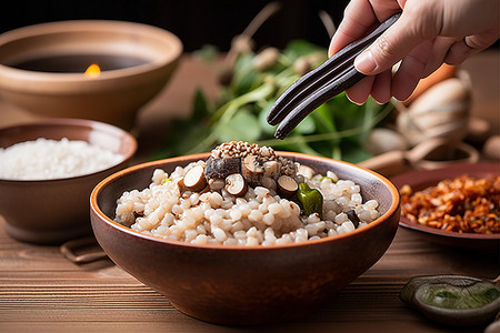 一个人将米饭倒入一个大碗中，放在蔬菜和其他食物上
