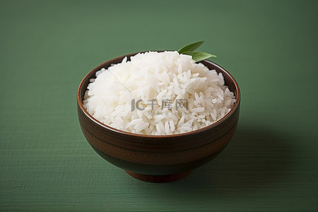 棕色背景上的一碗绿色米饭，上面有绿叶