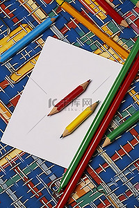 条纹板背景图片_带彩色铅笔和条纹板的回形针
