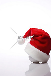 红色的帽子背景图片_一顶红色的圣诞老人帽子，白色表面上有一个白色的球