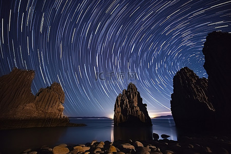 夜景背景图片_夜间在一些岩石地标上方的星轨