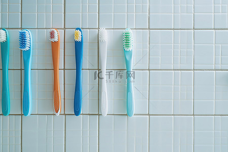 各种杯子背景图片_当人们准备上厕所时，瓷砖地板上放着各种颜色的牙刷
