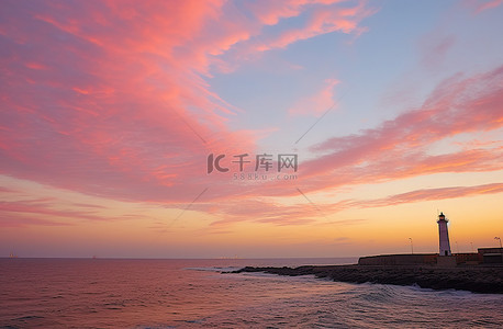 海洋灯塔背景图片_海洋日落和云中的灯塔