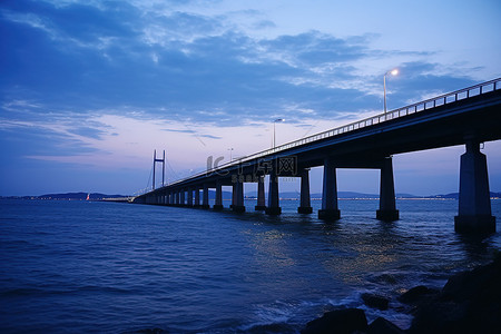 桥背景图片_这是美好的一天，黄昏时分，桥架在深蓝色的海洋上