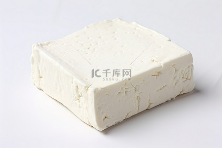 白色表面上的一块方形羊乳酪