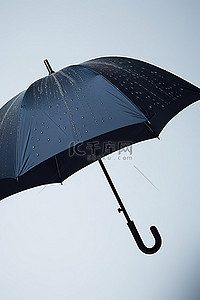 雨季背景图片_灰色的黑色雨伞和雨中的云彩