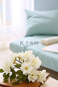 毯子背景图片_桌面上有白色的花朵，白色的毯子上有花朵