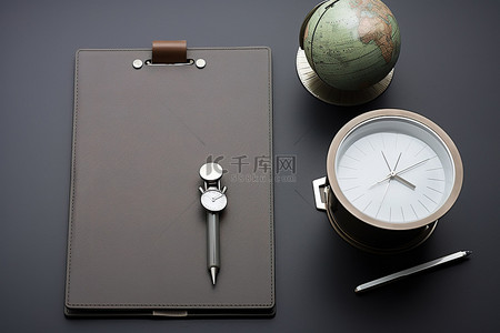 一本扁平的日记本位于两个剪贴板前面，上面有一个指南针