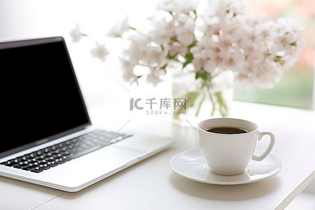 笔记本电脑前的一杯咖啡和花瓶