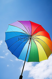 情侣撑伞背影背景图片_天空中撑着一把彩虹伞，映衬着蓝天