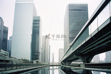 城市街道背景图片_一座横跨十字路口的桥梁，上面隐约可见摩天大楼