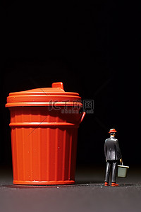 一个穿着西装的小个子男人在红色垃圾桶附近摆姿势