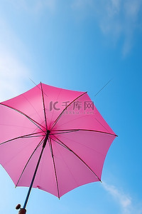 有天空背景的蓝色和粉色雨伞