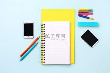 桌子上的手机背景图片_白色桌子上的手机记事本铅笔和其他几件物品
